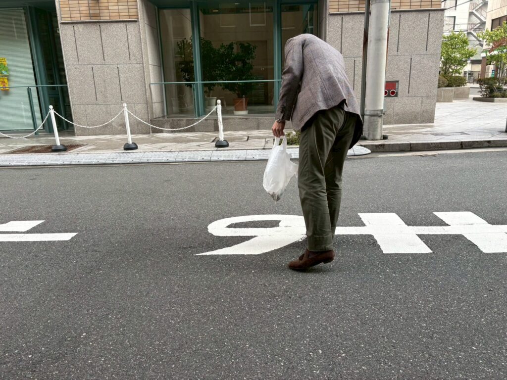 トングとゴミ袋を使用しゴミ拾いをする様子